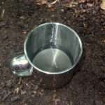 Das saubere, gefilterte Wasser in einem Edelstahlbecher. Mit dem PET-Wasserfilter wird das zuvor dreckige Wasser sichtbar gereinigt und verwertbar.